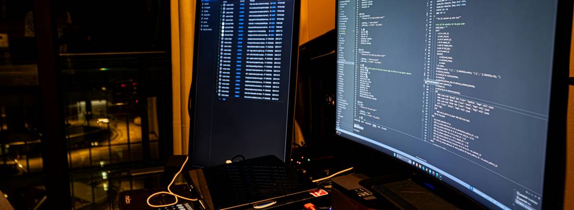Photo showing a developer working with code, test data files, and a CI/CD dashboard