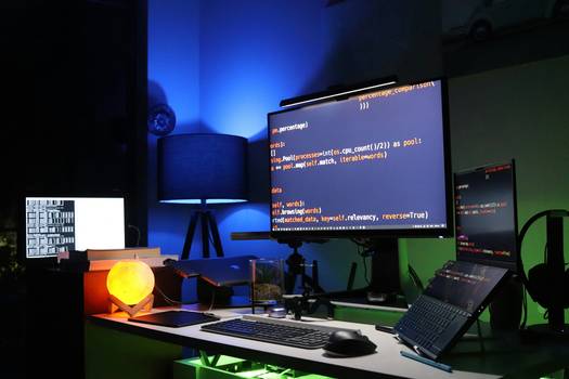 Photograph of a developer's workspace with code and anonymized data on screen, illustrating synthetic data and masking in action